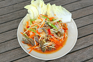 papaya salad with horse crab in plate against wood table
